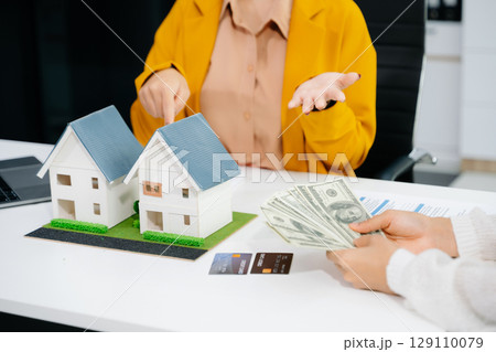 balancing the property sector The real estate agent is explaining the house style to see the house design and the purchase agreement. balancing the property sector The real estate agent is explaining the house style to see the house design and the purchase agreement. 129110079