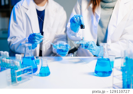 Scientist team meeting and writing analysis results in the laboratory study and analyze scientific 129110727