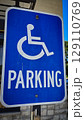 blue parking sign featuring a universal symbol for accessibility and the word PARKING. Highlights the availability of designated spaces for differently disabled individuals for convenience. 129110769