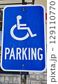 blue parking sign featuring a universal symbol for accessibility and the word PARKING. Highlights the availability of designated spaces for differently disabled individuals for convenience. 129110770