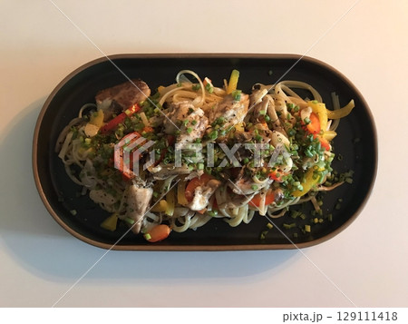 A plate of spaghetti pasta, perfectly cooked and topped with rich marinara sauce and fresh herbs. Ideal for food photography and menus, capturing the heart of Italian cuisine in a delicious way. 129111418