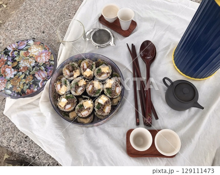 Delicious kimbap rolls filled with fresh vegetables, seasoned rice, and savory proteins, all wrapped in crisp seaweed. A perfect combination of flavor and texture in every bite. 129111473