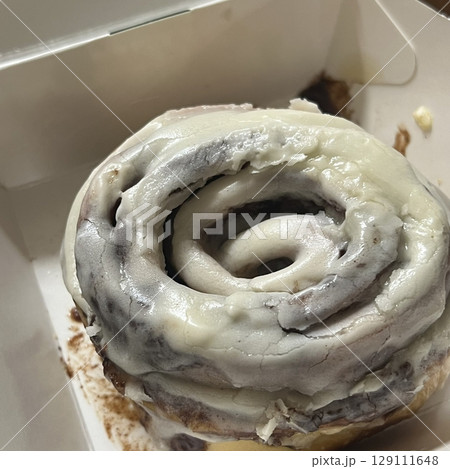 Soft, gooey cinnamon roll with a swirl of cinnamon sugar and a drizzle of creamy icing on top. Perfectly spiced and freshly baked, ideal for a cozy treat any time of day. 129111648