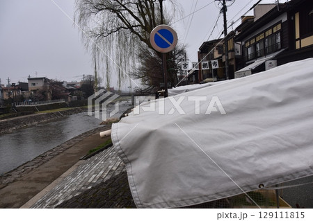 日本の岐阜県の高山市　中心部を流れる宮川と観光名所の宮川朝市　特産品を販売する露店や商店街 129111815