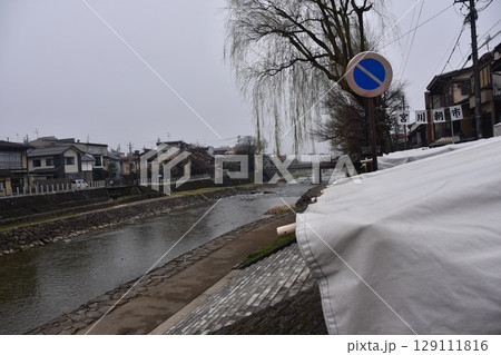 日本の岐阜県の高山市　中心部を流れる宮川と観光名所の宮川朝市　特産品を販売する露店や商店街 129111816