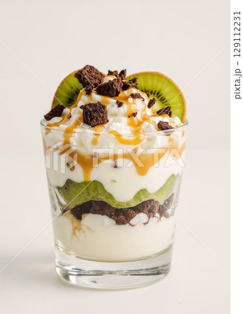 A gourmet layered dessert in a glass. This delicious parfait features layers of creamy yogurt, fresh kiwi fruit, and chocolate brownie, topped with a sweet caramel sauce. 129112231