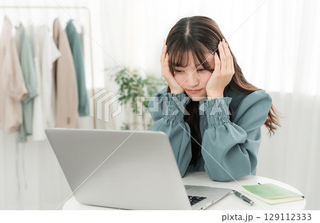 パソコンを見ながら落ち込む,考える,悩む若いアジア人ビジネスウーマン(ショック,絶望,投資,失敗) パソコンを見ながら落ち込む,考える,悩む若いアジア人ビジネスウーマン(ショック,絶望,投資,失敗) 129112333