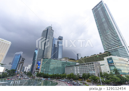 Jakarta, Indonesia - Mar 30,2024 : View of Bundaran HI along Jendral Sudirman road in Jakarta, Indonesia on Mar 30,2024. Jakarta, Indonesia - Mar 30,2024 : View of Bundaran HI along Jendral Sudirman road in Jakarta, Indonesia on Mar 30,2024. 129112454