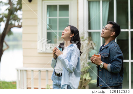 Joyful moments. Young couple enjoying coffee outdoors in a serene environment. 129112526