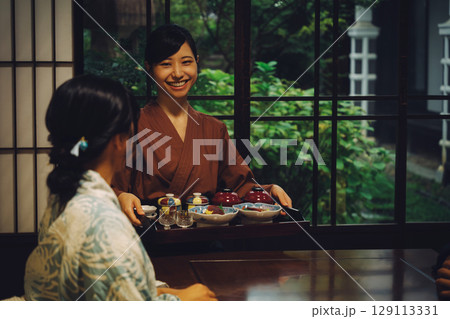 旅館,割烹日本料理店で食事を配膳する旅館スタッフの女性,仲居,女将 129113331