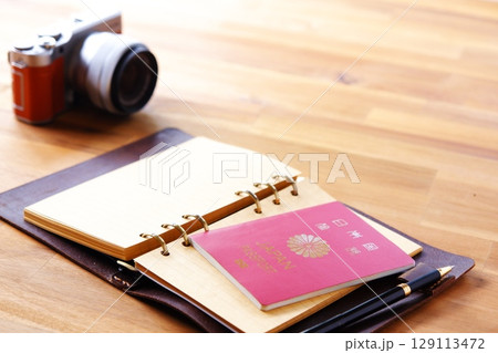 パスポート - パスポート（一般旅券10年用赤色）とカメラを用意して、海外旅行を計画しているイメージ 129113472