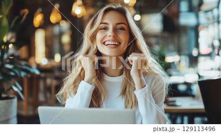 成功を喜ぶ女性の明るい笑顔とガッツポーズのポートレート 129113496