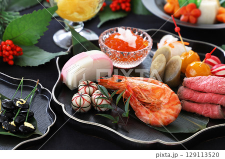 黒いプレートに盛られたおせち料理 129113520