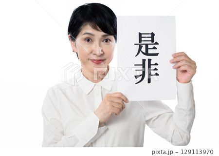是非と書かれた紙を持つ白いシャツを着たシニア女性 是非と書かれた紙を持つ白いシャツを着たシニア女性 129113970
