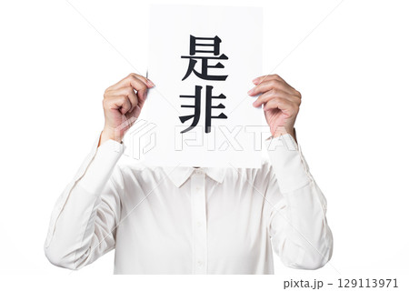 是非と書かれた紙を持つ白いシャツを着た人物 是非と書かれた紙を持つ白いシャツを着た人物 129113971
