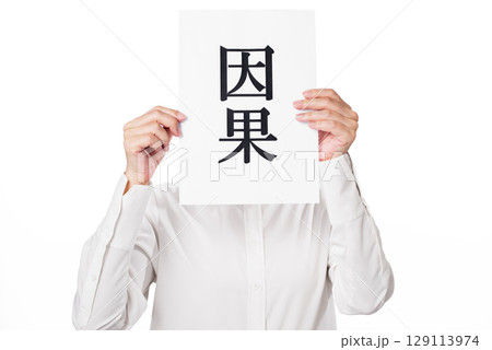 因果と書かれた紙を持つ白いシャツを着た人物 因果と書かれた紙を持つ白いシャツを着た人物 129113974
