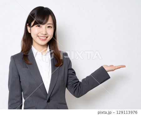 スーツ姿で案内する女性 129113976