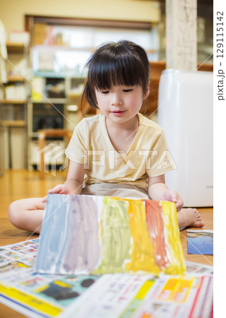 室内で絵の具を使ってお絵描きを楽しむ元気な女の子 室内で絵の具を使ってお絵描きを楽しむ元気な女の子 129115142