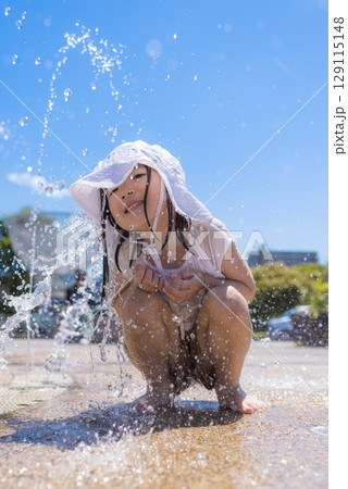 夏の日差しの中で噴水で水遊びを楽しむ子ども 夏の日差しの中で噴水で水遊びを楽しむ子ども 129115148