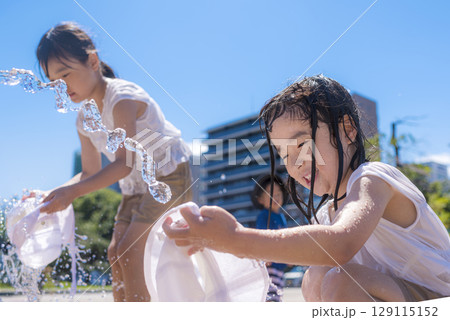 夏の日差しの中で噴水で水遊びを楽しむ子ども 夏の日差しの中で噴水で水遊びを楽しむ子ども 129115152
