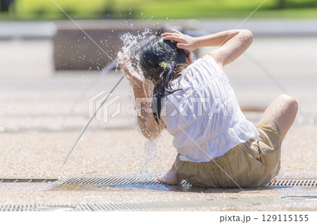 噴水の広場で水しぶきを浴びながら遊ぶ女の子 噴水の広場で水しぶきを浴びながら遊ぶ女の子 129115155