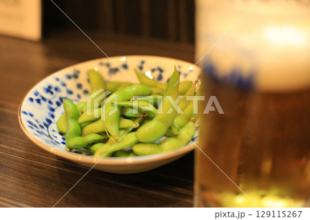居酒屋で楽しむ枝豆とビール 129115267
