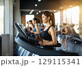 ジムのマシンでトレーニングする若い女性 129115341