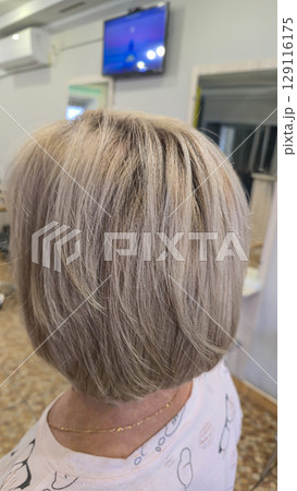 Woman with long light dyed hair standing in beauty salon with back. Ash shade. Woman with long light dyed hair standing in beauty salon with back. Ash shade. 129116175