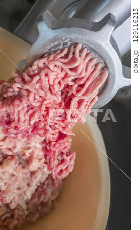 Meat grinder with fresh minced meat on the kitchen table Close-up of minced meat Meat grinder with fresh minced meat on the kitchen table Close-up of minced meat 129116215