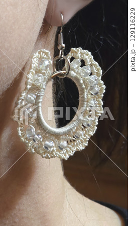 Round earrings made of thin cotton threads in the ear of a girl. Handmade. Round earrings made of thin cotton threads in the ear of a girl. Handmade. 129116229