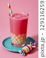 Bright pink fruit drink with tapioca balls at the bottom. Bright background, cooling drink. 129116259