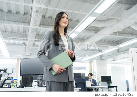 オフィスで仕事をする若いビジネスウーマン オフィスで仕事をする若いビジネスウーマン 129116453