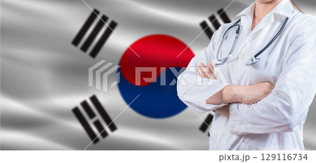 Doctor with crossed arms on South Korea flag. South Korea health and care concept. Female doctor on South Korea flag 129116734