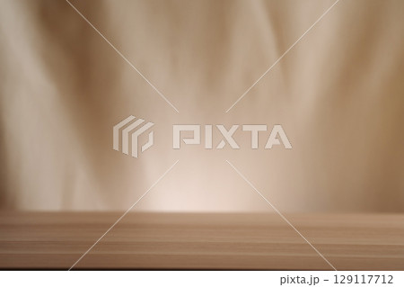A simple wooden table with a beige backdrop, symbolizing minimalistic living. Uncluttered presentation for stylish concepts. A simple wooden table with a beige backdrop, symbolizing minimalistic living. Uncluttered presentation for stylish concepts. 129117712