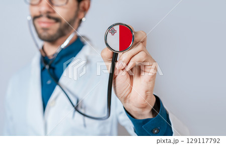 Doctor holding stethoscope with Malta flag. Malta health and care concept, Malta flag on stethoscope 129117792