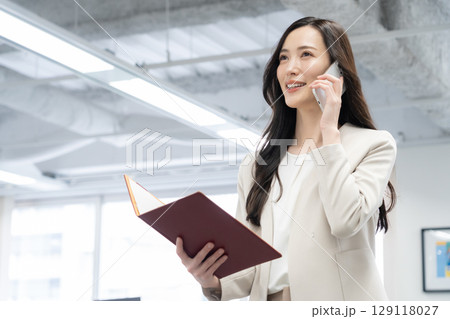 オフィスで仕事をする若いビジネスウーマン オフィスで仕事をする若いビジネスウーマン 129118027
