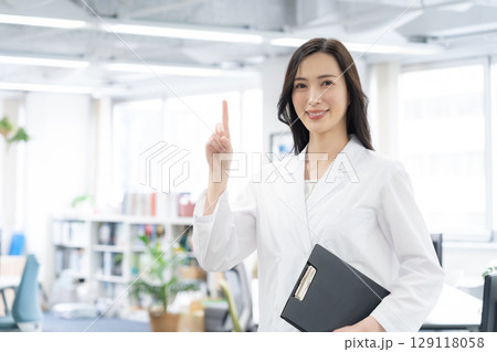研究所で実験をする白衣の若い女性研究者 129118058