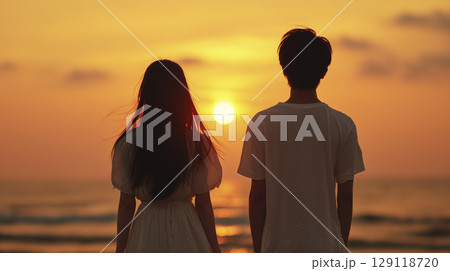 夕暮れのビーチで並んで過ごす 129118720
