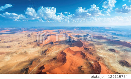 Red desert with sand dunes stretching as far as the eye can see. 129119784