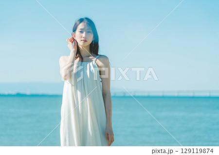 海を背景にした若い女性 海を背景にした若い女性 129119874