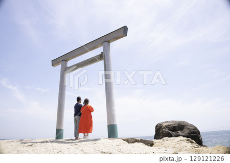 海岸沿いの鳥居の前に立つふたり 海岸沿いの鳥居の前に立つふたり 129121226