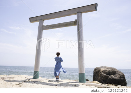 海岸沿いの鳥居の前に立つ女性 海岸沿いの鳥居の前に立つ女性 129121242
