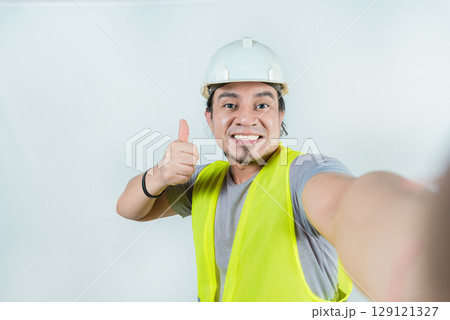 Self portrait of smiling engineer gesturing OK. Handsome engineer, smiling at the camera, showing approval Self portrait of smiling engineer gesturing OK. Handsome engineer, smiling at the camera, showing approval 129121327