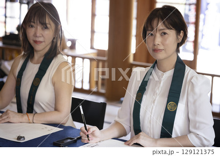 お寺で写経体験をする女性 129121375