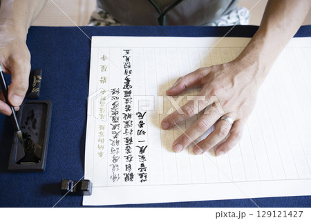 お寺で写経体験をする男性 129121427