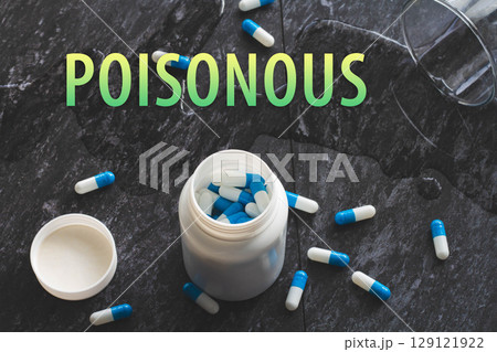 The inscription poisonous on the background of pills on a black table. The inscription poisonous on the background of pills on a black table. 129121922
