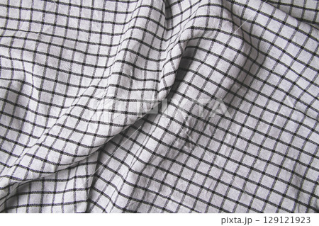Plaid material. Towel on the table. Wrinkled fabric with stripes. Plaid material. Towel on the table. Wrinkled fabric with stripes. 129121923