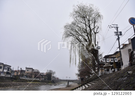 日本の岐阜県の高山市　中心部を流れる宮川と観光名所の宮川朝市　特産品を販売する露店や商店街 129122003