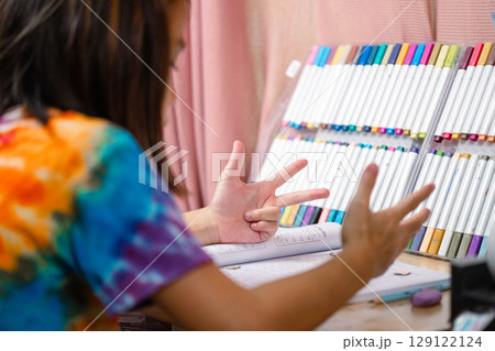 Two elementary school girls are studying at their desks at home. Two cute schoolgirls are diligently doing their homework. Two elementary school girls are studying at their desks at home. Two cute schoolgirls are diligently doing their homework. 129122124
