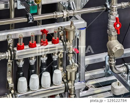 Piping and valve system in a modern industrial facility showcasing advanced plumbing technology Piping and valve system in a modern industrial facility showcasing advanced plumbing technology 129122784
